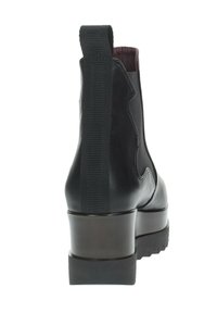 Stivale alla caviglia in pelle nera con pannello elastico laterale, punta tondeggiante e tacco spesso e texturizzato. Superficie liscia con un colore interno a contrasto.