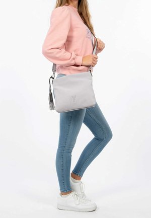 Borsa crossbody grigia con texture e chiusura a zip, dotata di un tassello removibile e di un logo sottile. Tracolla regolabile per un trasporto confortevole.