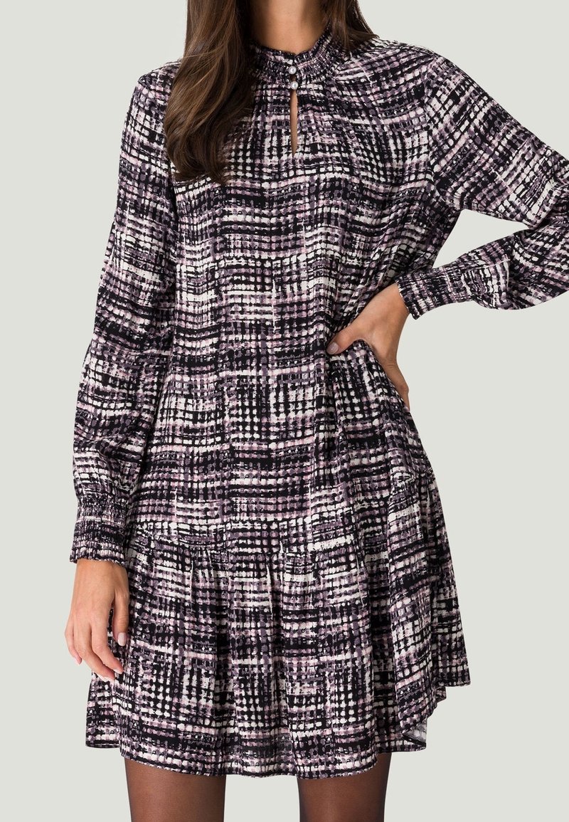 Robe à manches longues avec motif à carreaux abstraits noir, blanc et rose, col montant froncé avec bouton et ourlet évasé.