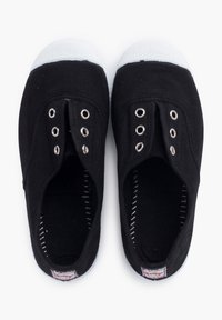 Czarne płócienne buty sportowe o niskim kroju, z srebrnymi oczkami i białymi gumowymi noskami. Wnętrze wykończone jest fakturowaną czarną podszewką.