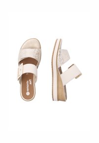 Sandales compensées blanches avec une sangle en argent texturé, boucle ajustable et semelle intérieure marron ; semelle en caoutchouc avec un léger relief pour l'adhérence.