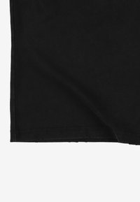 Czarna bawełniana tkanina o gładkiej fakturze, z prostym brzegiem i widocznym przeszyciem wzdłuż dołu.