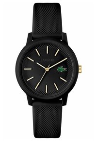 Must have tekstuuriga matt must korpus, kuldsed tunni näitajad ja käed. Tume kummirihm, millel on mustriline tekstuur ja Lacoste logo.