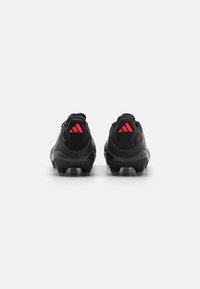 Black football shoes featuring a sleek design, textured synthetic material, and red accent details at the heel and logo.