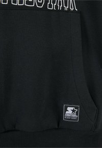 Čierny pulóver s kapucňou a prednou vreckom, s bielym textom a malým logom Starter Black Label v dolnom ľavom rohu. Mäkká textúra látky.
