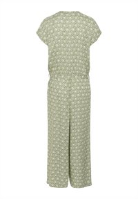 Une combinaison verte à motifs avec des manches courtes, une taille élastique, des jambes larges et un motif de feuilles dans une teinte plus claire. Fabriquée en tissu léger.