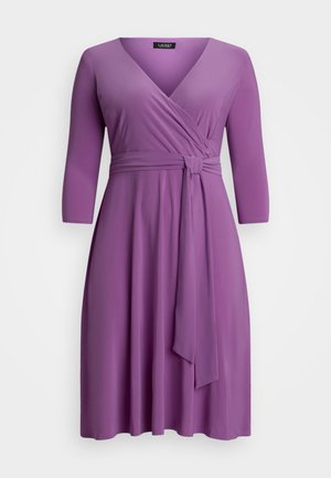 Fioletowa sukienka o kroju kopertowym z rękawami o długości trzy czwarte, z wiązanym w talii paskiem i gładką, matową fakturą. Prosty krój z dekoltem w kształcie litery V.