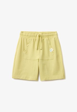 Hellgelbe elastische Shorts mit Kordelzug vorne und großen Vordertaschen, mit einem kleinen bunten Etikett auf der rechten Tasche.