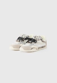 Αθλητικά παπούτσια με συνδυασμό υφασμένο γκρι σουέτ και αντανακλαστικό ασημί δίχτυ. Διαθέτουν μαύρα και μπεζ κορδόνια, με πατούμενο σε μπεζ σχέδιο.