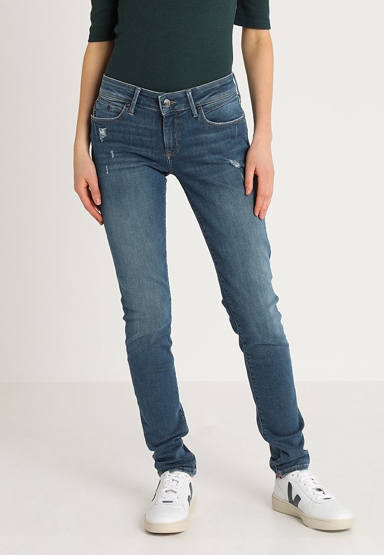Tunna denimjeans i medelblå med lätt slitage. Har en klassisk femficksdesign och en dragkedja med knappstängning.