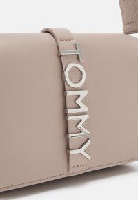 Tommy Jeans CITY BOLD FLAP CROSSOVER - Taška s příčným popruhem - drifty dunes