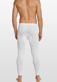 Weiße gerippte Leggings aus elastischem Stoff, mit einem runden Ausschnitt auf der Rückseite und enganliegenden Bündchen an den Knöcheln.