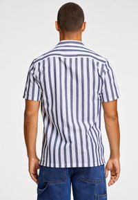 Korte mouwen overhemd met knopen, met verticale marineblauwe en witte strepen, ontspannen pasvorm, kraag met inkeping en rechte zoom.