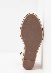 Semelle d'une espadrille beige avec une semelle en caoutchouc brun texturée et la taille 37 indiquée près du talon.