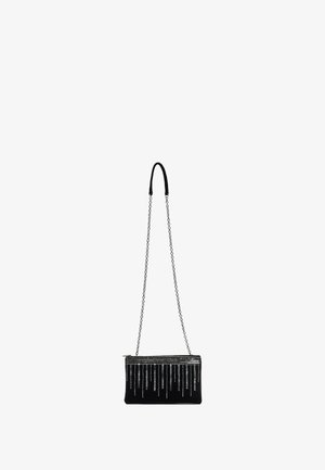 Crna torbica za večernje izlaske s teksturiranom površinom, srebrnim lancem i uzorkovnim metalnim detaljima duž vrha s vertikalnim linijama.