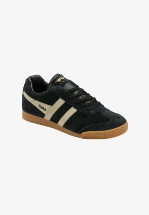 Gola sneakers in zwart suede met witte en beige strepen, zwarte veters en een gestructureerde rubberen zool. Heeft een logo op de zijkant en tong.