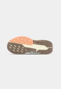 Shoe sole with a segmented design. Features rubber traction patterns in orange, brown, and cream colors. Textured detailing on the surface.