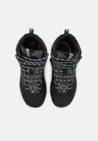 Botas de senderismo negras con un acabado texturizado, que cuentan con cordones azules y grises, un collar alto y una puntera reforzada para mayor durabilidad.
