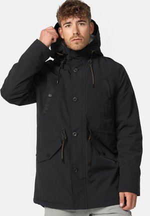 Parka noire avec capuche, dotée d'une fermeture éclair à l'avant, de deux grandes poches à l'avant et d'accents à cordon de serrage sur la capuche et à la taille.
