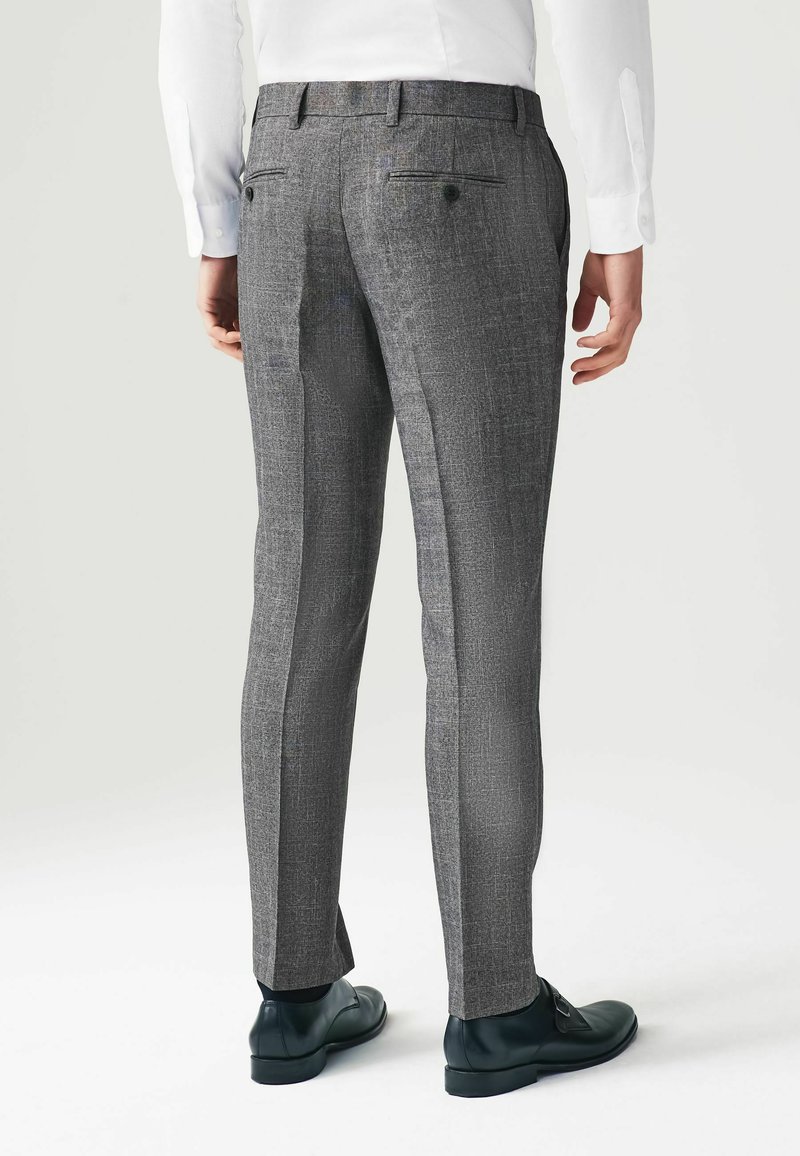 Schmal geschnittene graue Hosen mit einem strukturierten Muster, zwei Gesäßtaschen und einem sauberen Saum. Tragen Sie schwarze Schuhe, die ein maßgeschneidertes Design präsentieren.