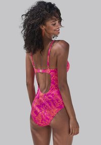 Rosa blommig baddress med låg ryggutskärning, tunna axelremmar och en mjuk textur med orange tropiska mönster.