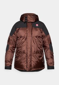 Giacca imbottita marrone con dettagli neri; presenta un cappuccio, chiusura a zip e polsini con velcro. Tessuto a trama con design trapuntato e dettaglio del logo.
