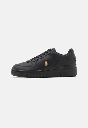 Svart lær sneakers med gullakenter, rund tå og perforeringer på overdelen. Har tonale snørebånd og en lagdelt såle.