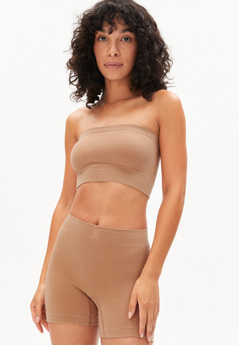 Beige ribbed bandeau top paired with matching high-waisted shorts. Both pieces feature a seamless design and fitted silhouette.