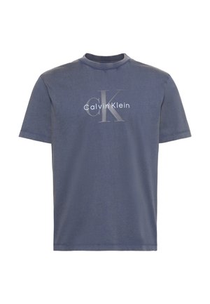 T-shirt bleu à manches courtes et col rond avec un grand logo texte "cK" gris clair et "Calvin Klein" blanc centré sur le devant.