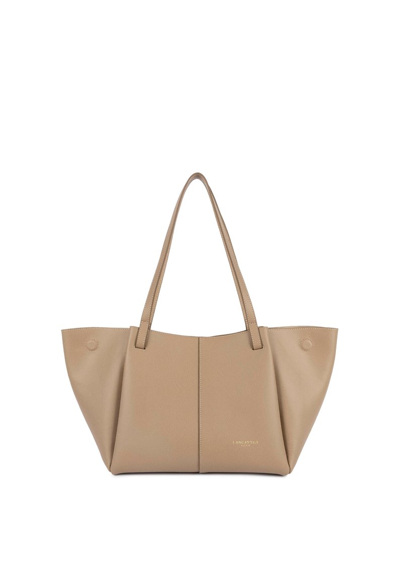 Borsa a tracolla beige con superficie testurizzata, due manici lunghi, apertura superiore e dettaglio circolare su un lato; design minimalista con marchio in rilievo.