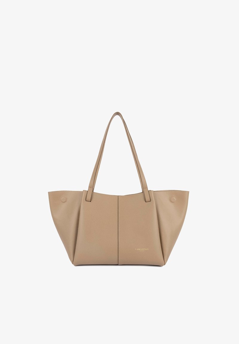 Borsa a tracolla beige con superficie testurizzata, due manici lunghi, apertura superiore e dettaglio circolare su un lato; design minimalista con marchio in rilievo.