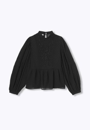 Blouse noire à basque avec manches longues bouffantes, tissu texturé, col montant et broderie florale sur le devant. Ouverture en forme de trou de serrure dans le dos.