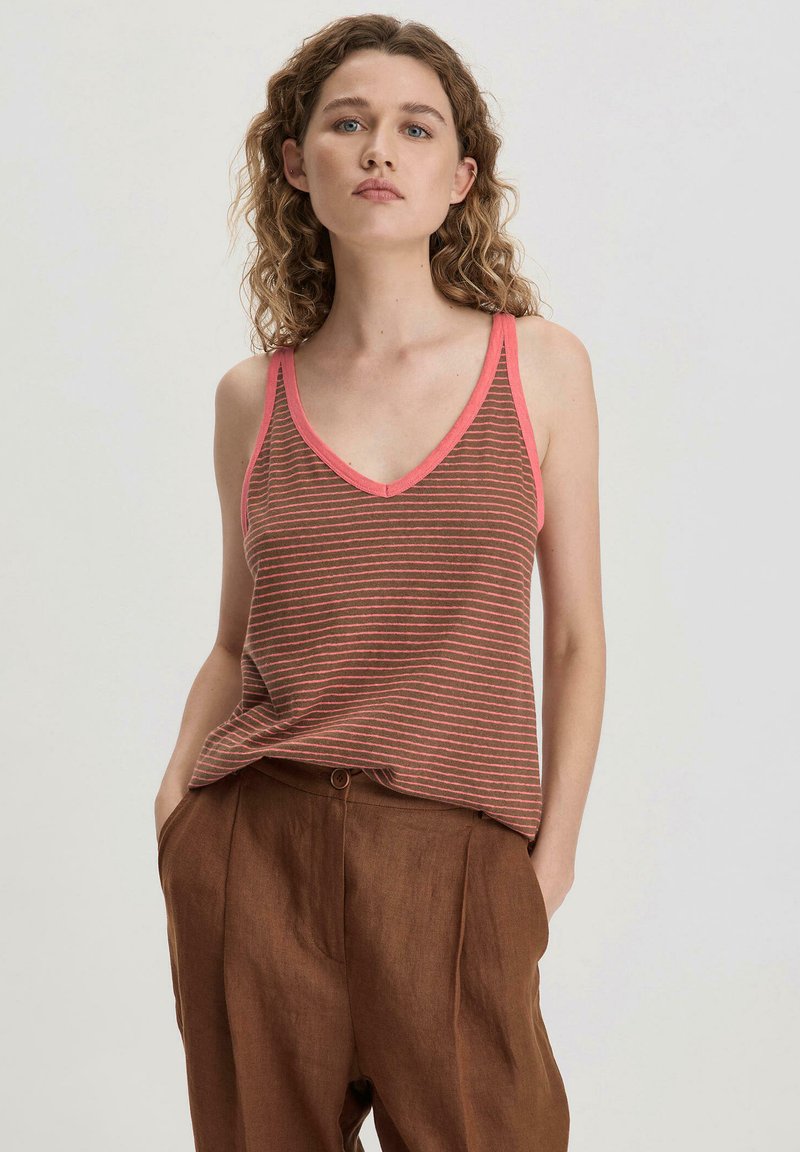 Gestreept tanktop in bruin en koraal met een V-hals, voorzien van dunne schouderbandjes en een losse pasvorm, gecombineerd met bruine broek.
