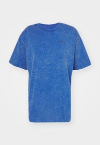 Modrý tričko s krátkými rukávy vyrobené z texturované látky, s kulatým výstřihem a malou nášivkou loga na přední straně.