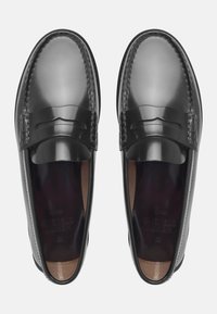 Black leather loafers with a shiny finish, featuring a horizontal strap design and pronounced stitching along the edges. Smooth, textured interior.
