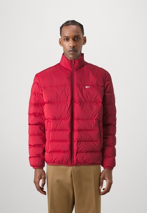 Chaqueta de plumas roja con un alto cuello, cremallera frontal y diseño de paneles horizontales. Textura suave, con dos bolsillos externos.