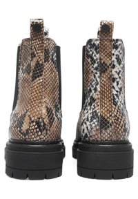 Bottines à motifs serpent brun et noir avec une semelle épaisse et des côtés élastiques, dotées d'une boucle de tirage pour un enfilage facile.