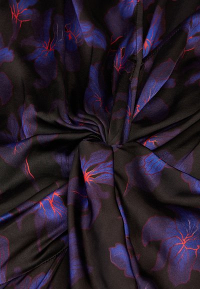 Tejido con fondo negro y grandes patrones florales azules acentuados por venas rojas, creando una apariencia suave y texturada.