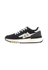 Scarpa atletica nera e grigia con accenti bianchi, tomaia in tessuto testurizzato, design del logo a contrasto, lacci bianchi e suola robusta.