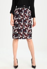 Spódnica ołówkowa w geometryczne wzory w kolorach burgund, granatowym i kremowym. Posiada dopasowany krój i gładką strukturę materiału.
