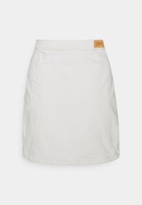 Valkoinen farkkuhame suoran leikkauksen omaavana, jossa on näkyvä sauman yksityiskohta ja ruskea etiketti, jossa lukee "ONLY" vyötärölinjassa.