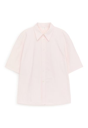 Chemise rose clair à manches courtes avec des boutons et un col pointu, étalée à plat sur un fond blanc.