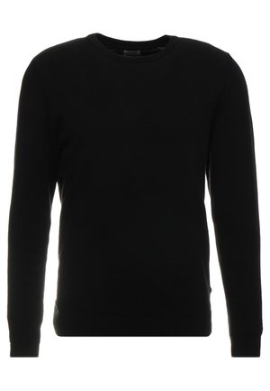 Zwarte pullover trui van zachte stof, met een ronde hals, lange mouwen en geribbelde accenten bij de manchetten en de zoom.