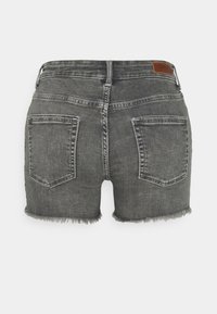 Harmaat farkkushortsit, joissa on risat lahkeet, kaksi takataskua ja ruskea nahkabrändilogo vyötärön yläpuolella.