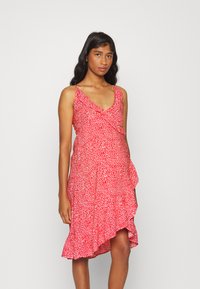 Vestido de padrão floral vermelho com decote em V, alças finas e bainha com volantes, feito de tecido leve para um design fluido.