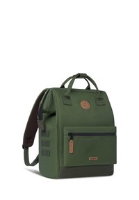 Groene stoffen rugzak met een gestructureerd oppervlak, gevoerde schouderbanden, een ritsvak aan de voorkant en leren accenten. Heeft dubbele handvatten bovenaan.