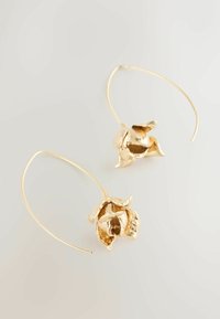 Gold hoop earrings with a floral design, featuring textured petal details and a smooth finish. The hoops are slender and delicate.