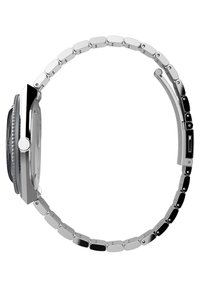 Montre en métal argenté avec une lunette noire, un cadran rectangulaire et un bracelet à maillons. Présente un motif texturé sur la lunette et des maillons polis.