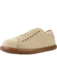 Sneaker beige perforato con punta arrotondata, suola piatta in gomma marrone e design minimalista con lacci. Texture liscia e stile casual.