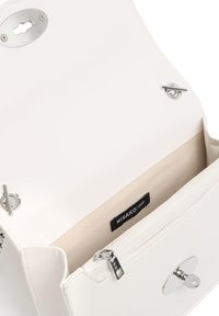 Borsa a tracolla in similpelle bianca con dettagli in metallo argentato, chiusura magnetica e tasca interna con zip. Fodera in tessuto beige, logo visibile all'interno.